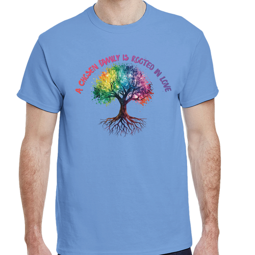 A man wearing a Carolina Blue t-shirt featuring a colorful graphic of a tree with a rainbow-colored canopy and roots, with the text 'A Chosen Family is Rooted in Love' arched above it in pink and purple lettering.