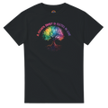 A black t-shirt featuring a colorful graphic of a tree with a rainbow-colored canopy and roots, with the text 'A Chosen Family is Rooted in Love' arched above it in pink and purple lettering.