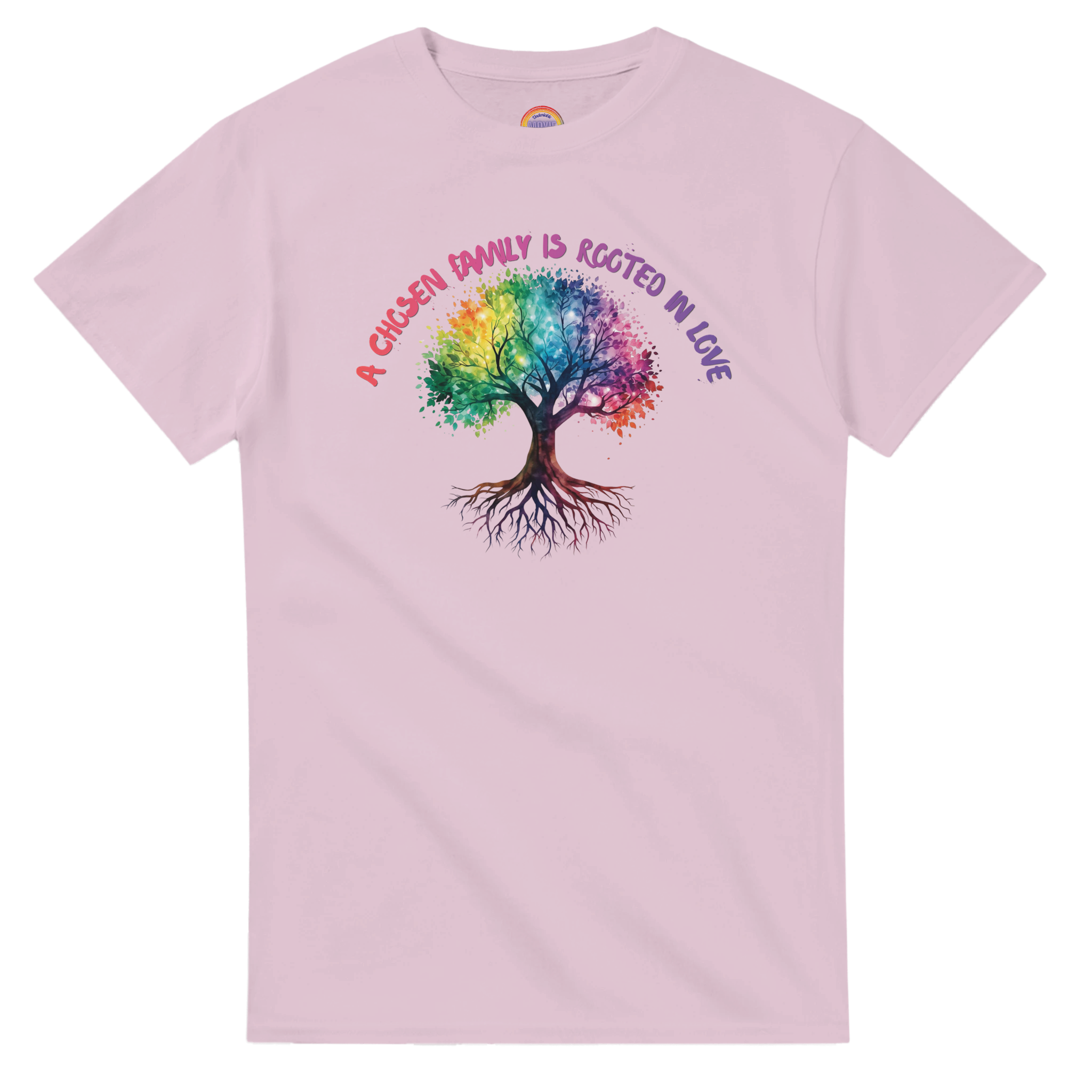 A light pink t-shirt featuring a colorful graphic of a tree with a rainbow-colored canopy and roots, with the text 'A Chosen Family is Rooted in Love' arched above it in pink and purple lettering.
