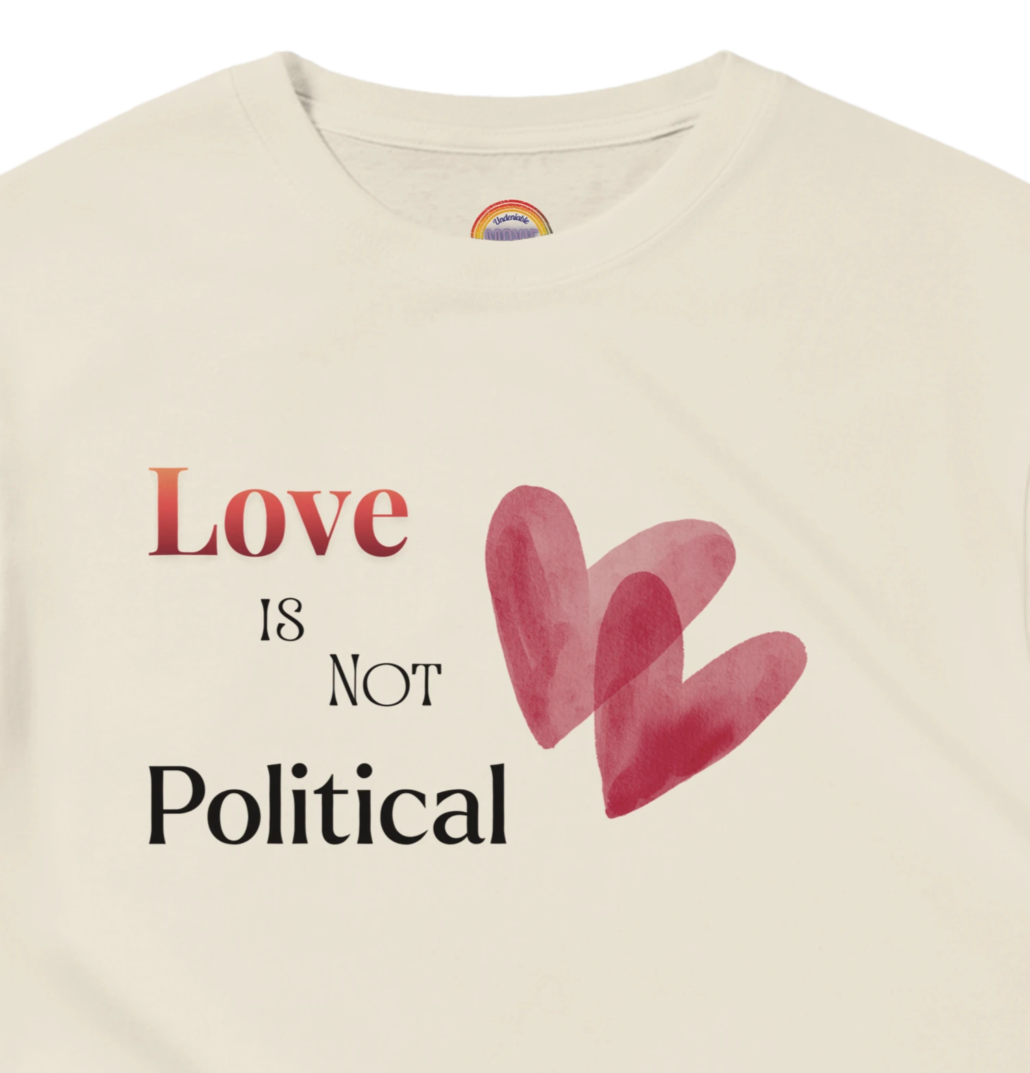 Natural Beige short-sleeve tee with a graphic print on the chest reading 'Love IS NOT Political' in black and red text, accompanied by two overlapping red hearts. 